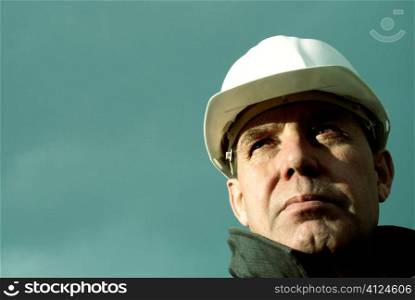 man with white hard hat, special photo toned f/x, focus point on the eye