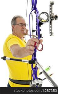 Man with yellow shirt and jeans aiming with a bow and arrow in close up