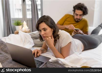 man woman checking their devices home