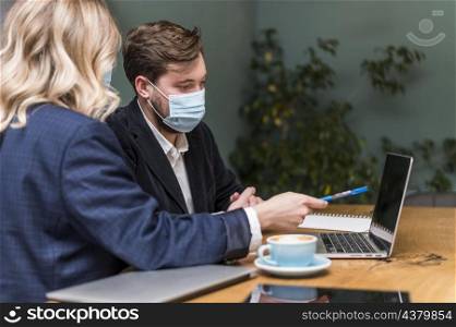 man woman talking about new project while wearing medical masks