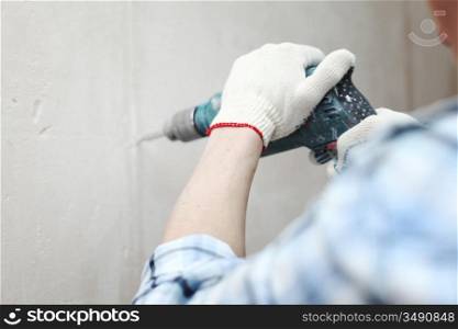man worker hammer drills wall