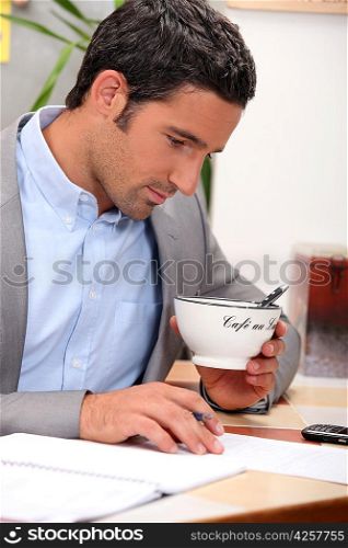Man working and holding a cup