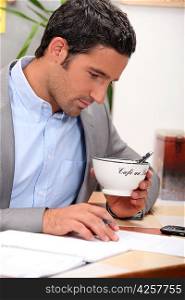 Man working and holding a cup