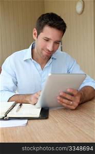 Man working at home with electronic tablet