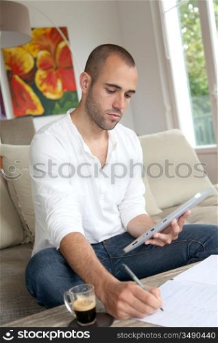 Man working at home with electronic tablet