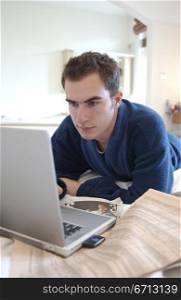man working at laptop in bed