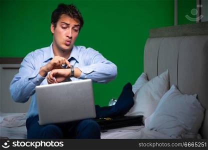 Man working at night at home. Young businessman under stress in the bedroom at night