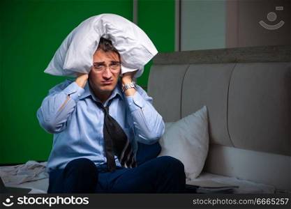 Man working at night at home. Young businessman under stress in the bedroom at night
