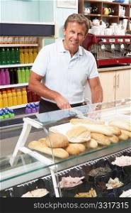 Man Working Behind Counter In Cafe