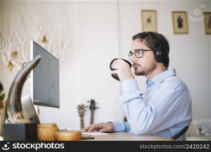 man working computer drinking