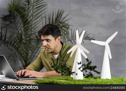 man working eco friendly wind power project with wind turbines laptop