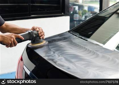 Man working for polishing, coating cars. polishing of the car will help eliminate contaminants on the surface of the car.Waxing the car surface will cause shine after polishing the car.