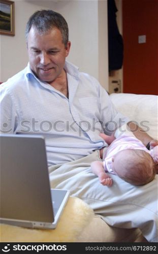 man working from home with baby