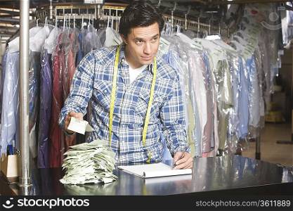 Man working in the laundrette documenting receipts