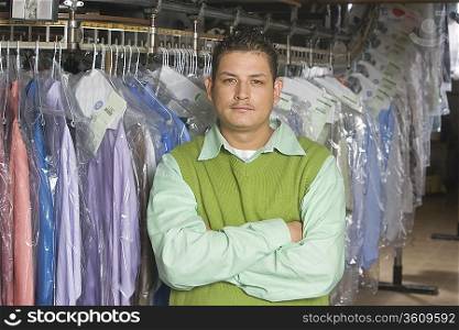 Man working in the laundrette standing infront of clothes rail