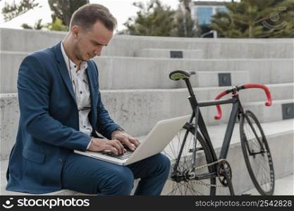man working laptop his bike outdoors 2