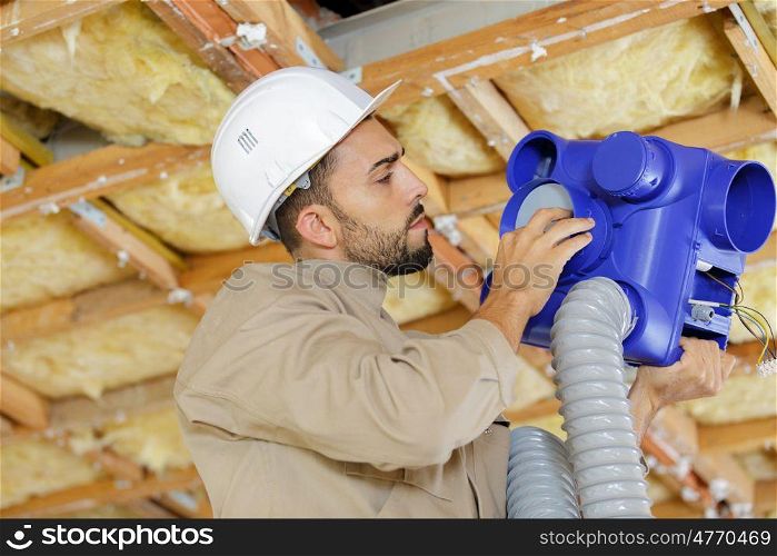 man working on ceiling pipes