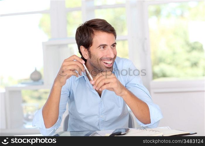 Man working on electronic tablet in office