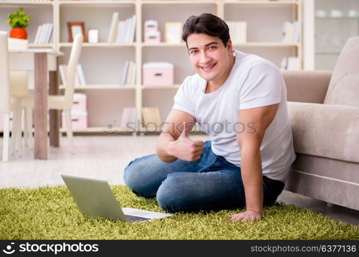 Man working on laptop at home on carpet floor