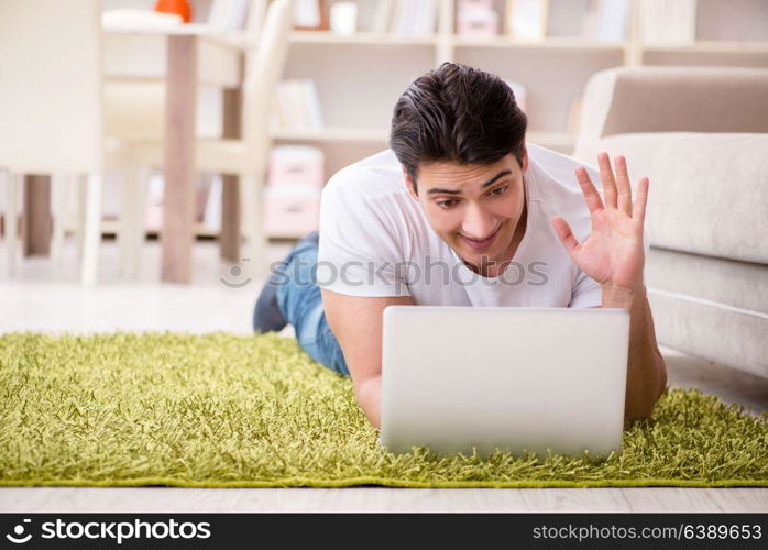 Man working on laptop at home on carpet floor