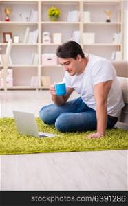 Man working on laptop at home on carpet floor