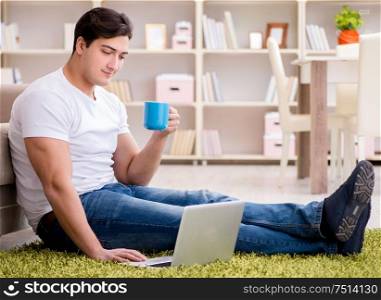 Man working on laptop at home on carpet floor. The man working on laptop at home on carpet floor