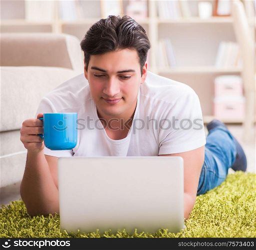Man working on laptop at home on carpet floor. The man working on laptop at home on carpet floor