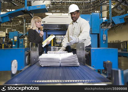 Man working on newspaper production line in newspaper factory