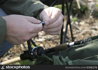 Man working on preparing his angling gear for a fishing session