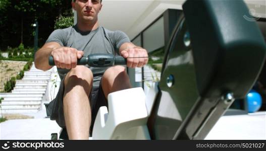 Man Working Out On Row Machine in front of home