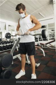 man working out while wearing medical mask gym