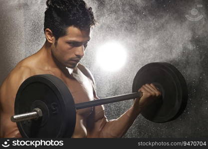 Man working out with barbells over a dark background. 