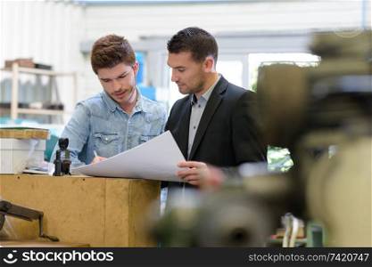 man working with apprentice in printing house