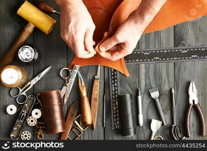 Man working with leather using crafting DIY tools