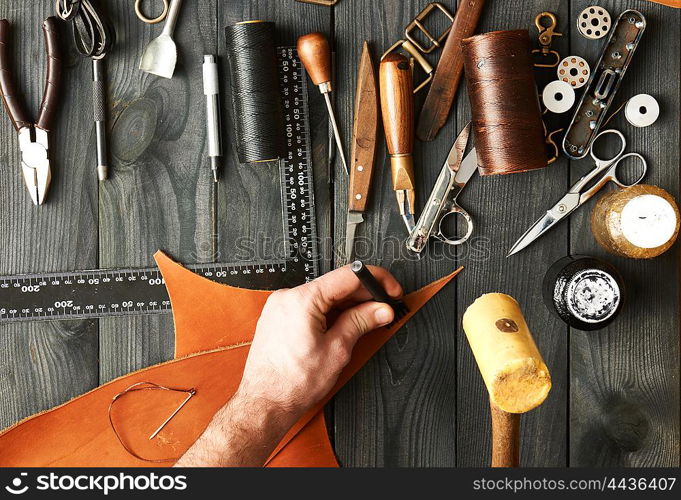 Man working with leather using crafting DIY tools