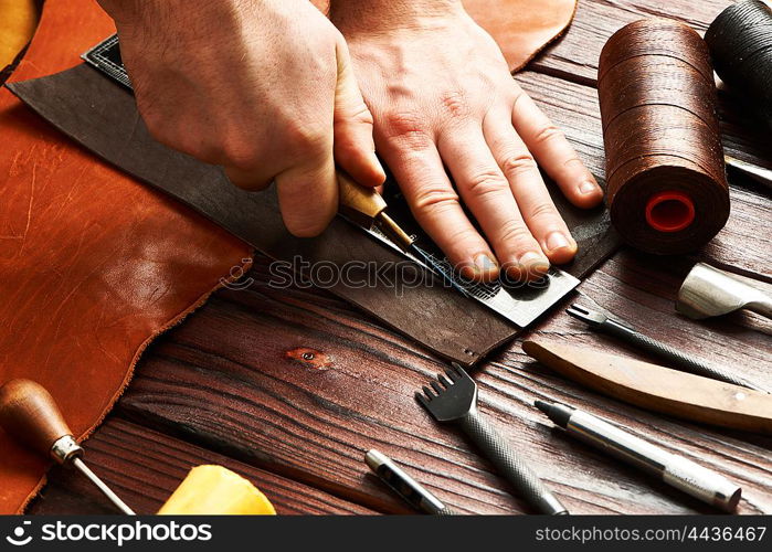 Man working with leather using crafting DIY tools