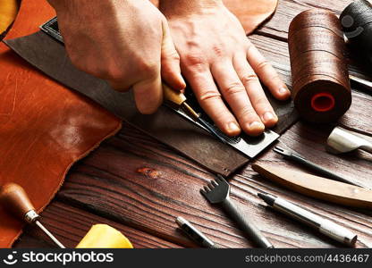 Man working with leather using crafting DIY tools