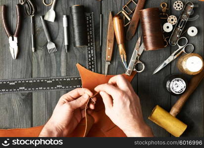 Man working with leather using crafting DIY tools