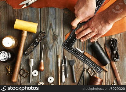 Man working with leather using crafting DIY tools