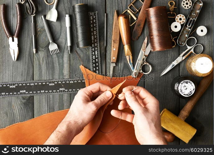 Man working with leather using crafting DIY tools