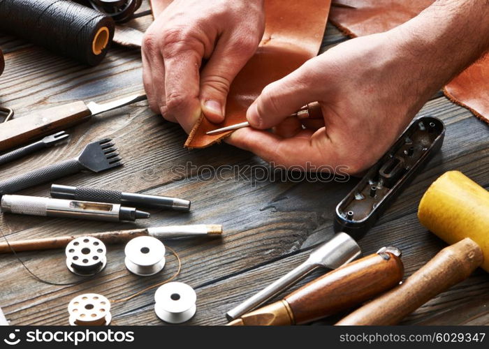 Man working with leather using crafting DIY tools