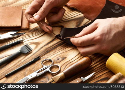 Man working with leather using crafting DIY tools