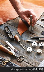 Man working with leather using crafting DIY tools