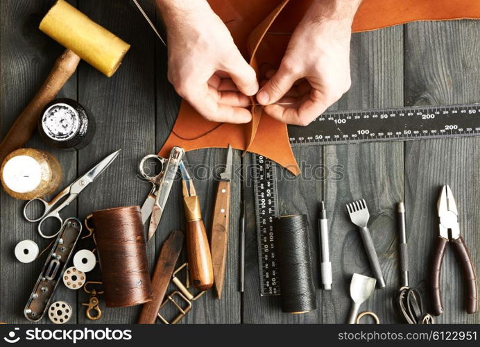 Man working with leather using crafting DIY tools