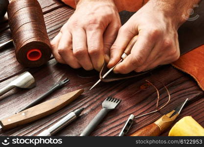 Man working with leather using crafting DIY tools