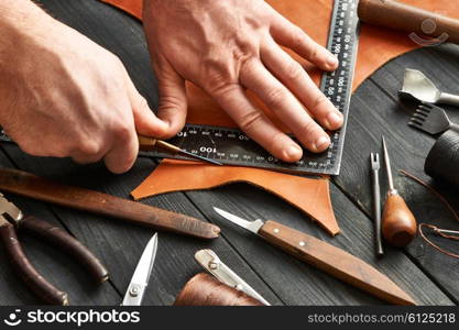 Man working with leather using crafting DIY tools