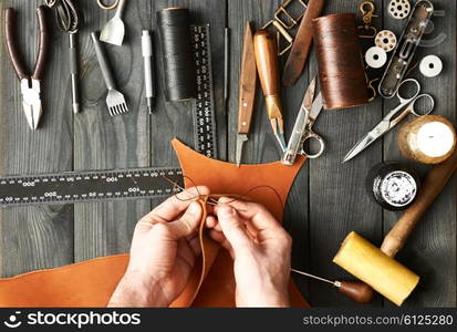 Man working with leather using crafting DIY tools