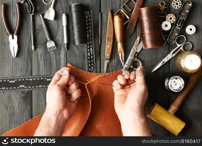 Man working with leather using crafting DIY tools