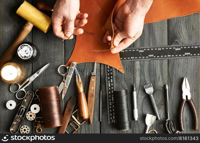 Man working with leather using crafting DIY tools