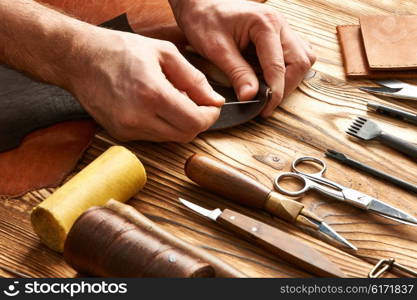 Man working with leather using crafting DIY tools